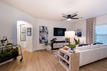 a living room with a white couch and a ceiling fan
